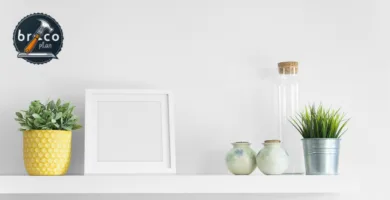 Estantes flotantes minimalistas en pared blanca con macetas, plantas y decoración, logo Bricoplan esquina.